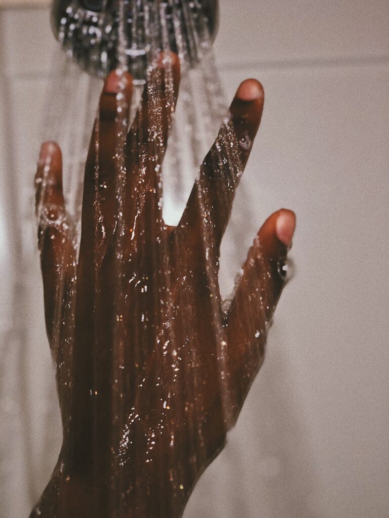 photograph of a hand under the shower