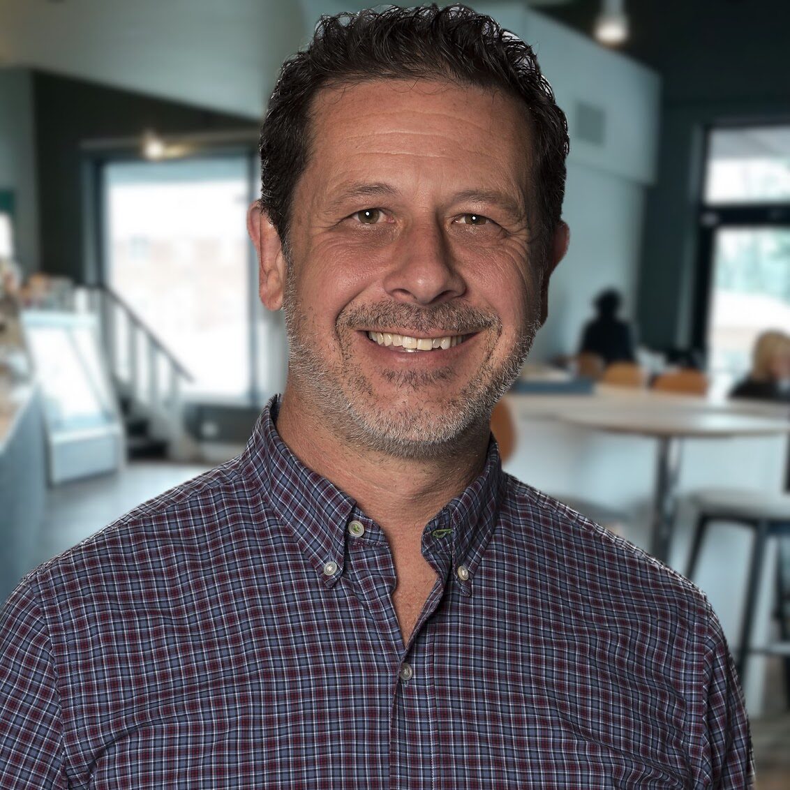 Headshot of Todd M Smith smiling in a coffee shop.